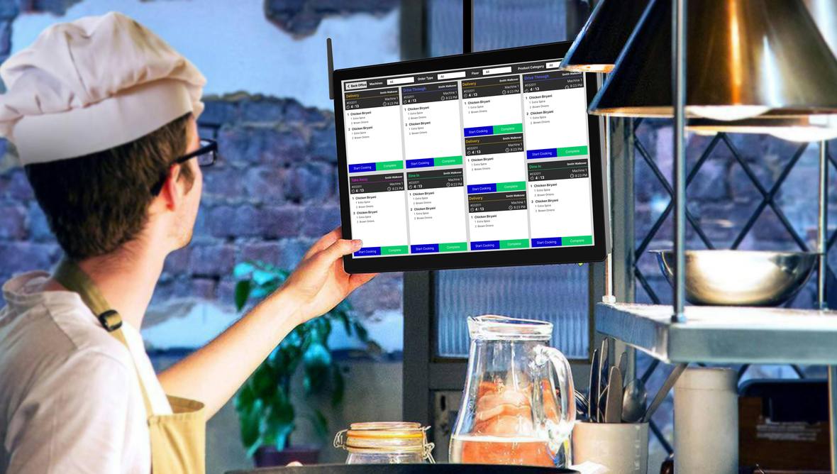 VisioEdge kitchen display screen mounted on a kitchen wall showing live order tickets