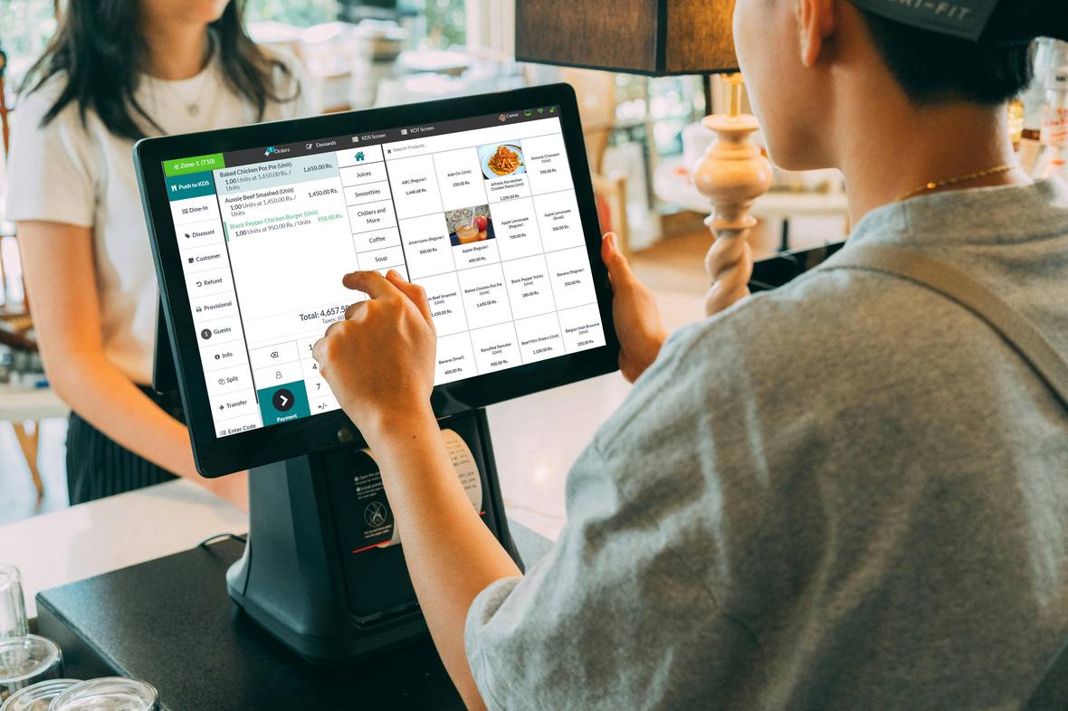 VisioEdge point of sale terminal at a counter with an open dine-in ticket and a customer waiting