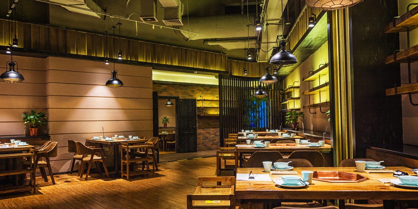 Dining room of a full-service restaurant with tables laid for service